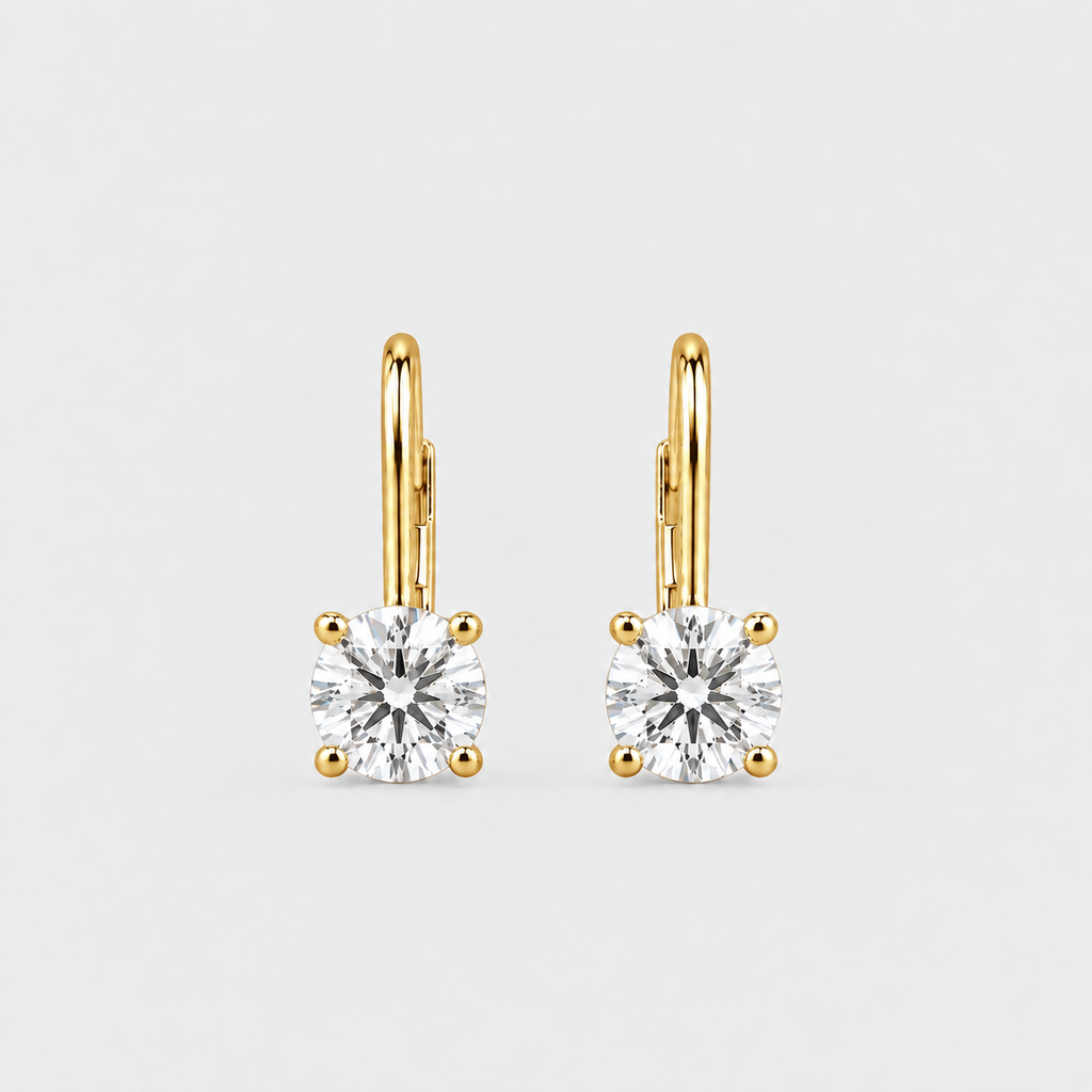 A pair of yellow gold leverback earrings, each featuring a round brilliant-cut clear gemstone in a four-prong setting, shown against a light gray background.