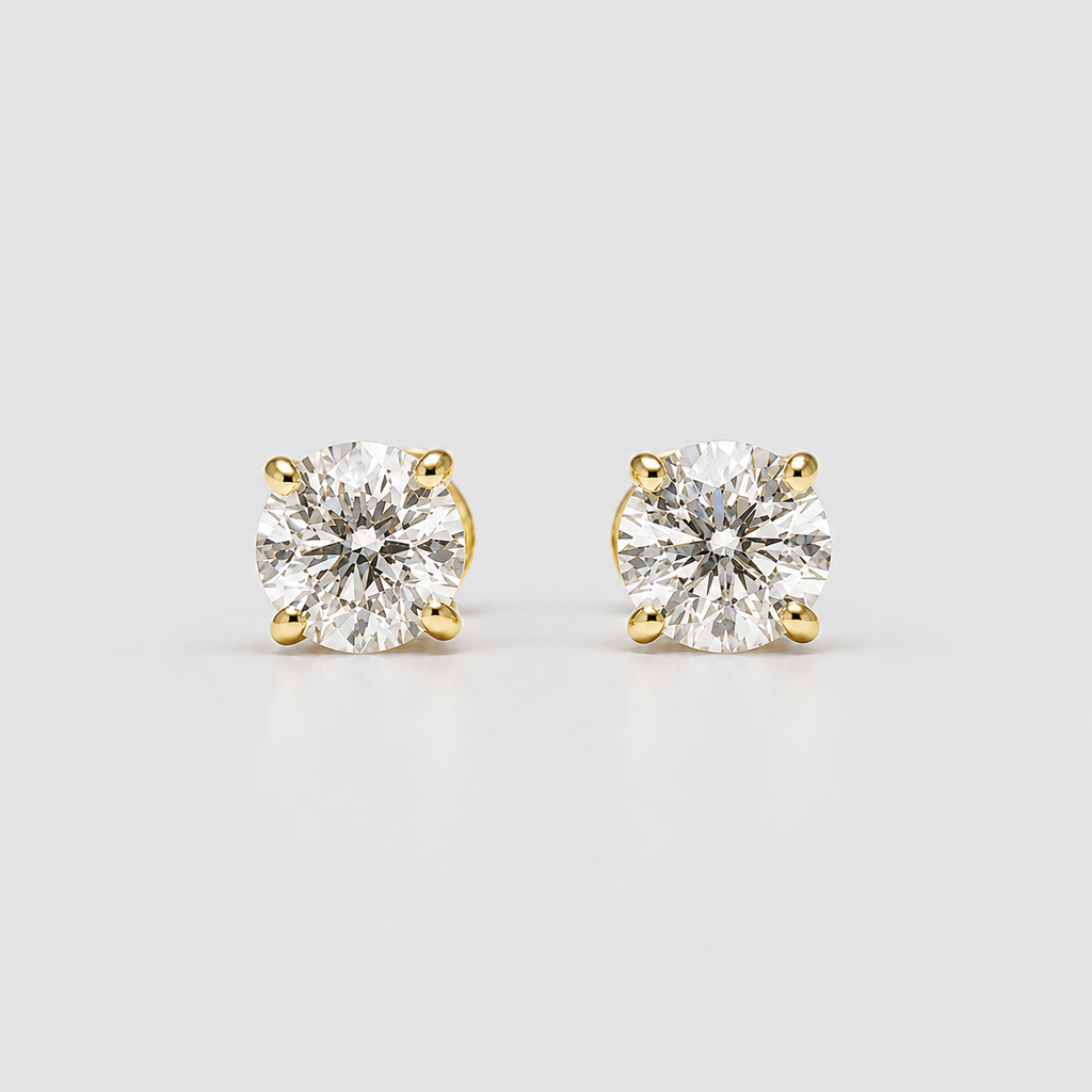A pair of yellow gold solitaire stud earrings with round brilliant-cut clear gemstones, set in a four-prong setting against a light gray background.