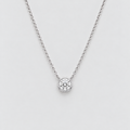 A delicate silver chain necklace with a single round bezel-set diamond pendant, shown against a clean light gray background.