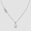 A delicate silver necklace with a single solitaire diamond pendant, displayed on a light gray background.