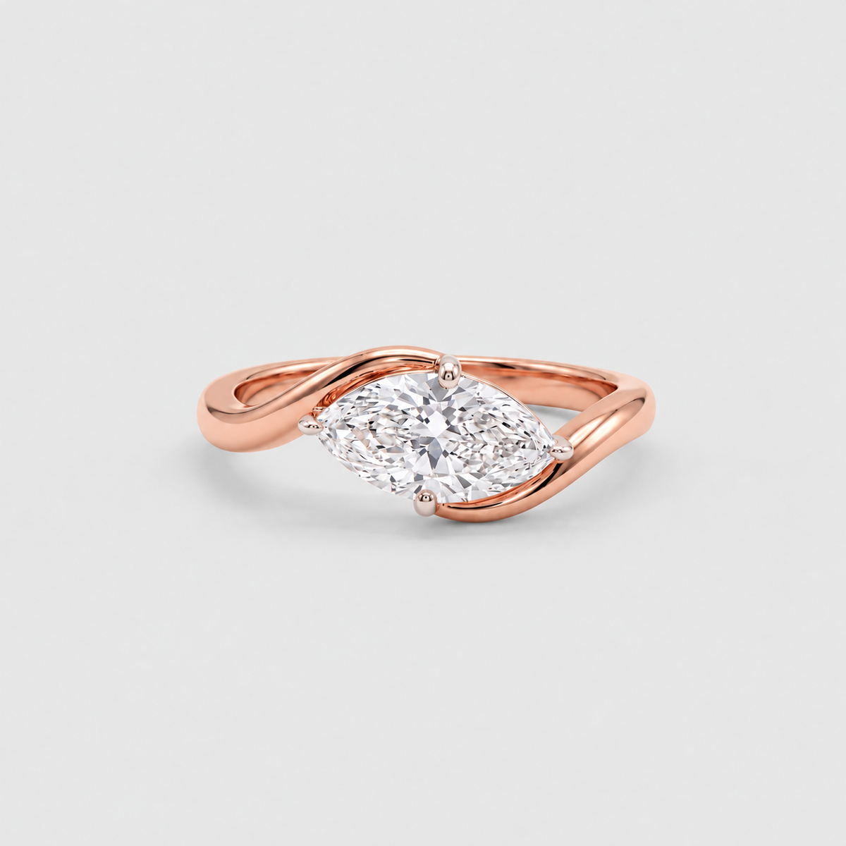 A rose gold ring with a twisted band and a marquise-cut diamond center stone, photographed on a clean light gray background.