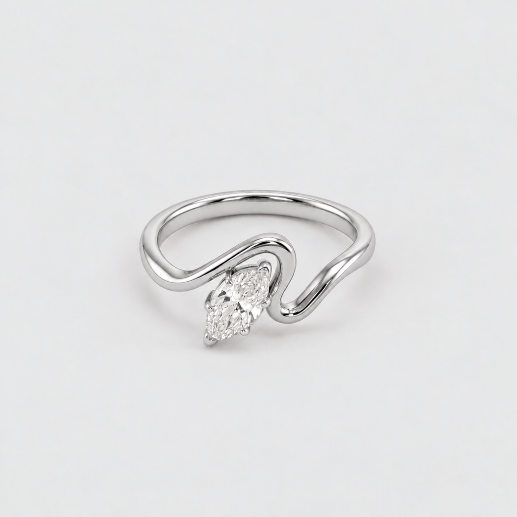 A silver ring with a curved, wave-like band and a marquise-cut clear gemstone, photographed on a clean white background.