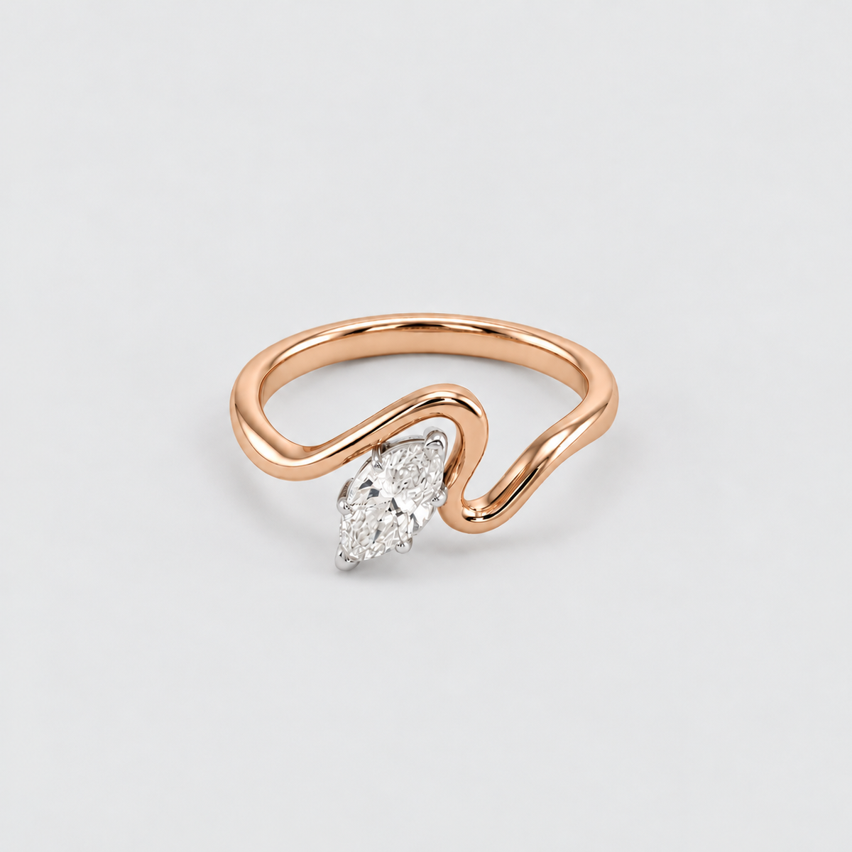 A rose gold ring with a wavy, open band design and a marquise-cut diamond set in a silver-colored setting, shown on a light gray background.