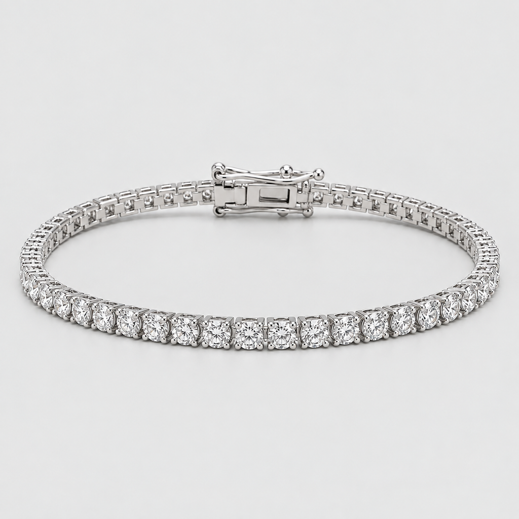 A tennis bracelet with a continuous row of round-cut clear stones in a silver-toned setting, featuring a clasp closure, shown on a light gray background.