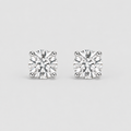 A pair of round brilliant-cut diamond stud earrings in a four-prong setting, shown on a light gray background.