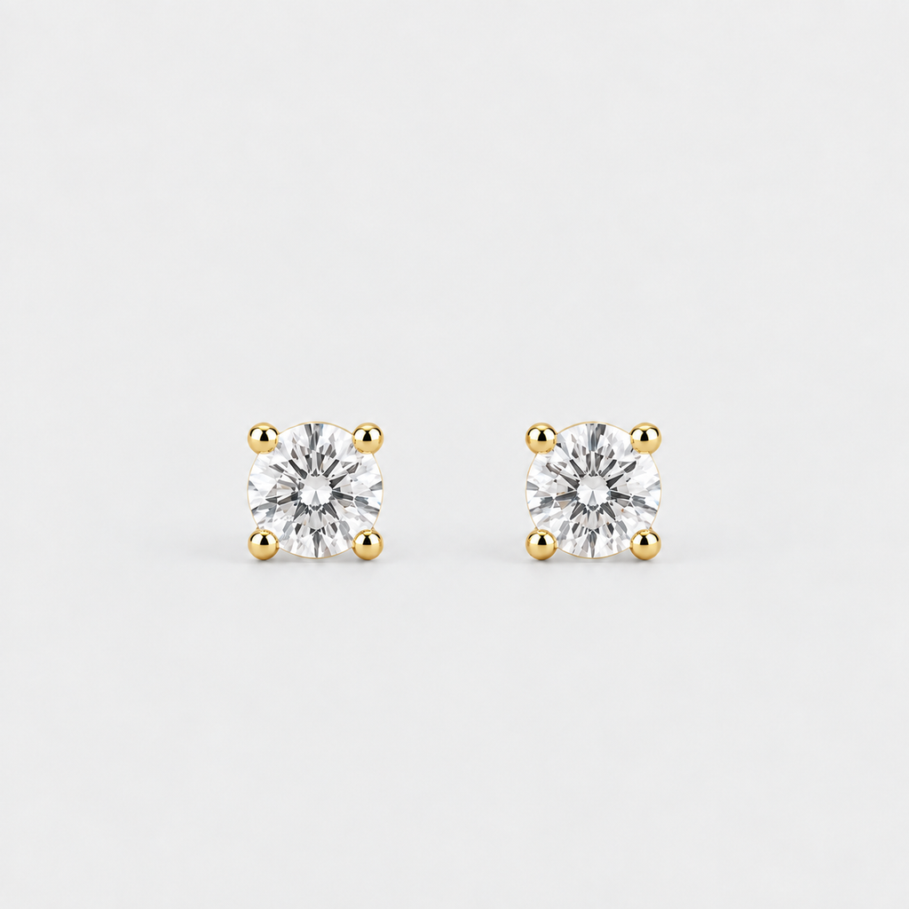 A pair of square-cut stud earrings with clear gemstones in yellow gold four-prong settings, shown on a light gray background.