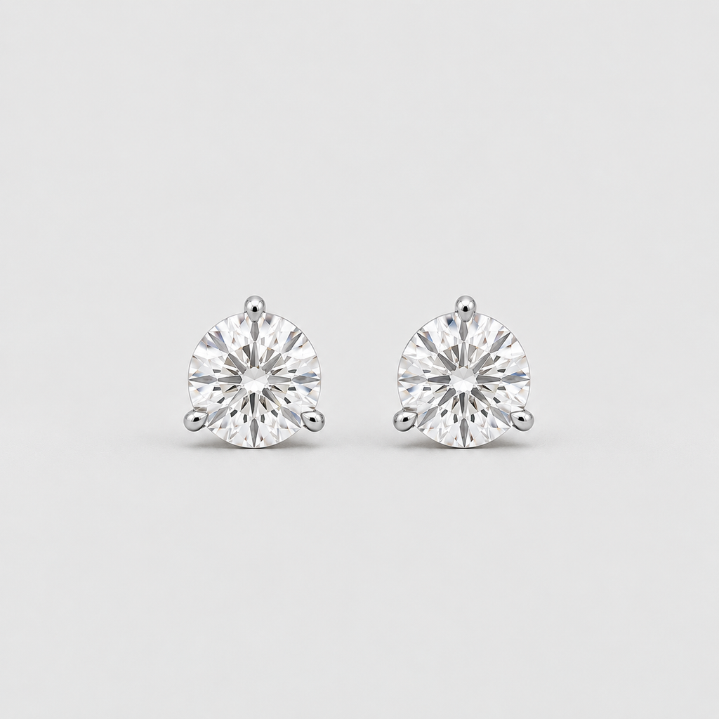 A pair of round-cut stud earrings in a silver-toned setting, photographed on a clean light gray background.