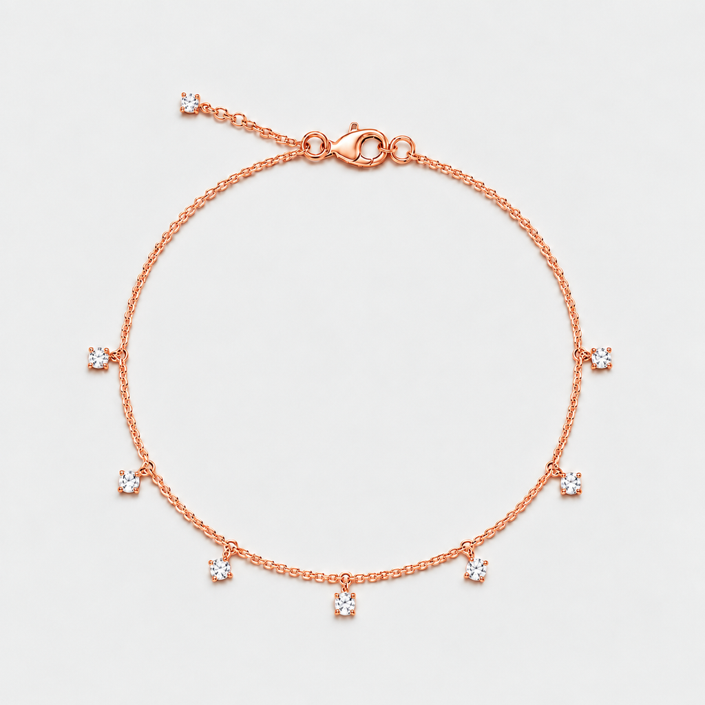 A delicate rose gold chain bracelet with a lobster clasp and five small bezel-set clear stones spaced along the chain, photographed on a clean light gray background.