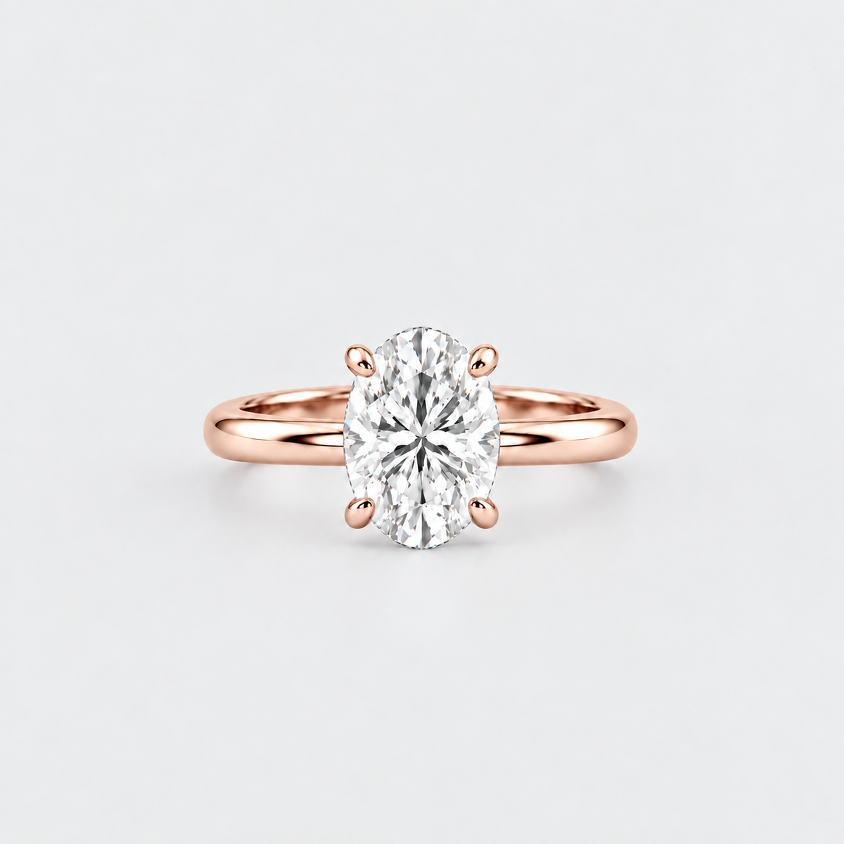 An oval-cut diamond engagement ring with a rose gold band in a six-prong setting, centered on a light gray background.