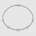 A silver chain bracelet with five small bezel-set round clear stones, displayed on a light gray background.