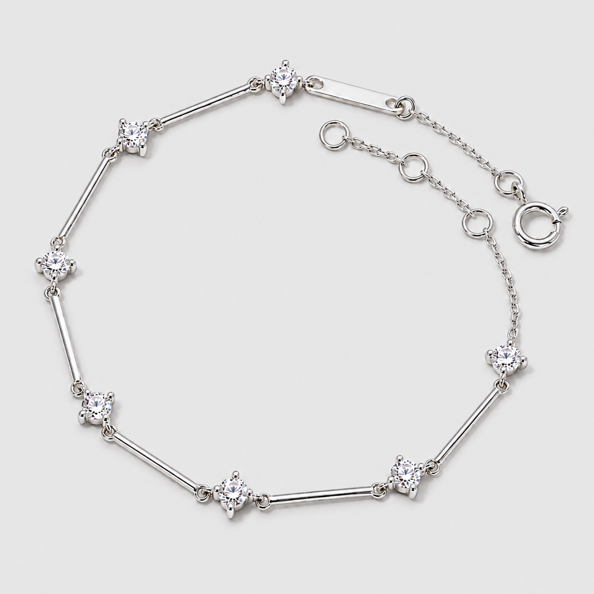 A silver-toned bracelet featuring alternating segments of polished bars and star-shaped settings with clear gemstones, displayed on a light gray background.