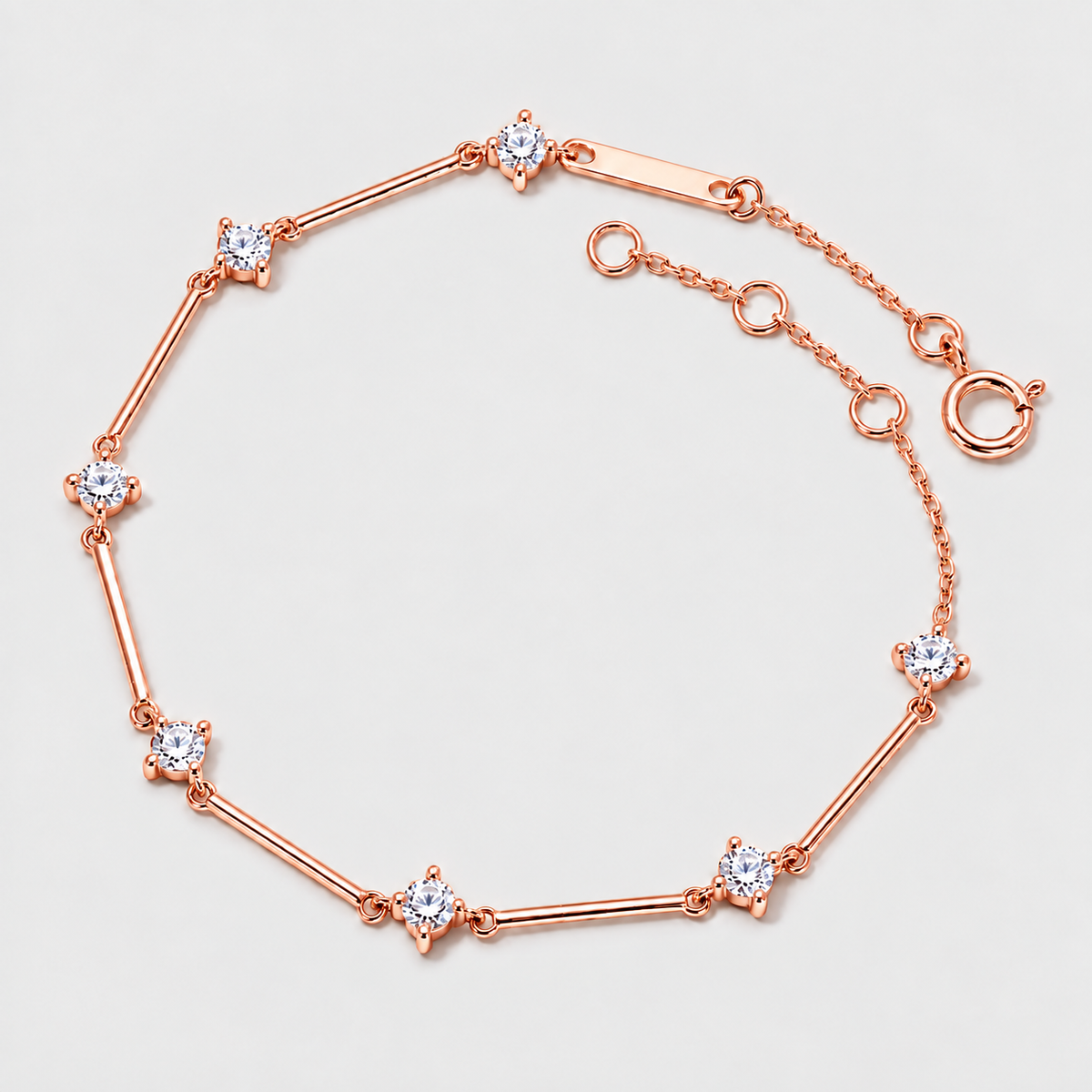 A rose gold bracelet with seven star-shaped settings, each holding a clear round gemstone, displayed on a light gray background.