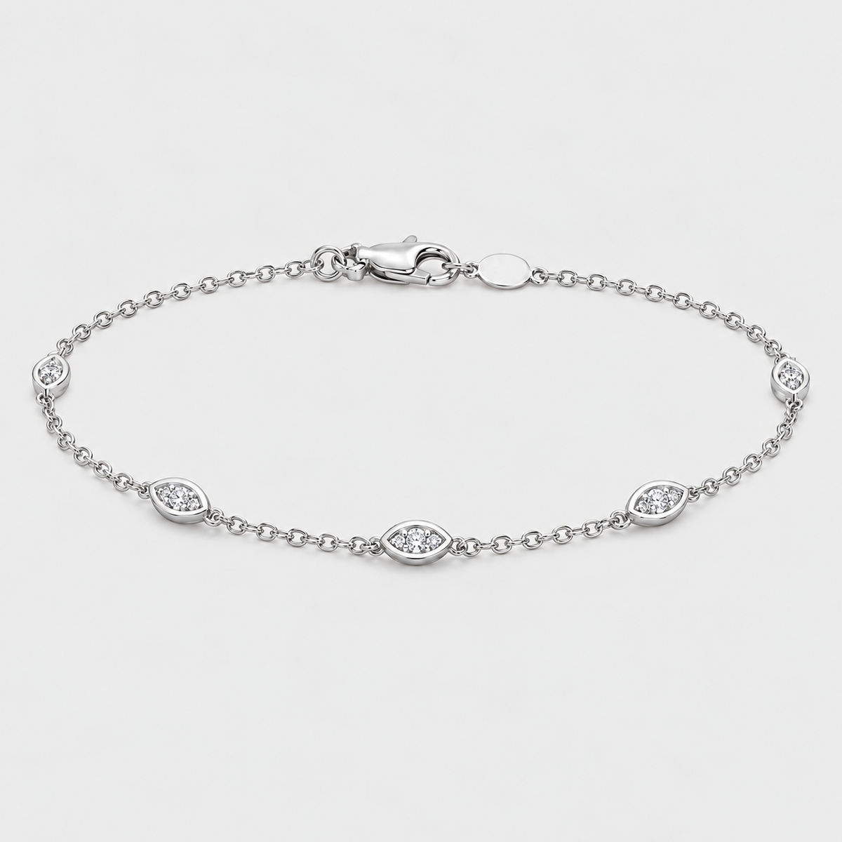A silver chain bracelet with five oval eye-shaped links, each set with a small clear gemstone, displayed on a light gray background.