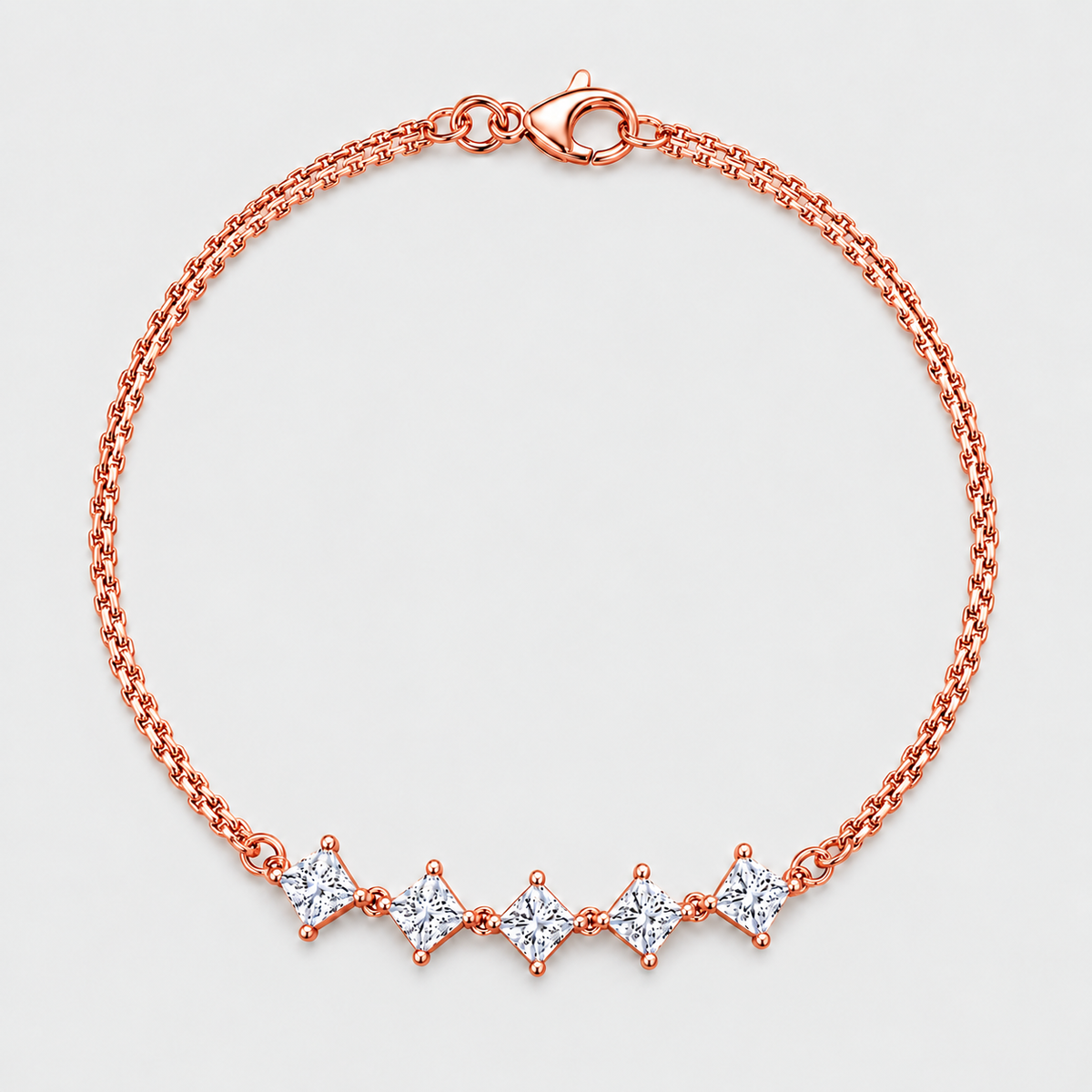 A rose gold chain bracelet with five diamond-cut clear gemstones set in a row on a light gray background.
