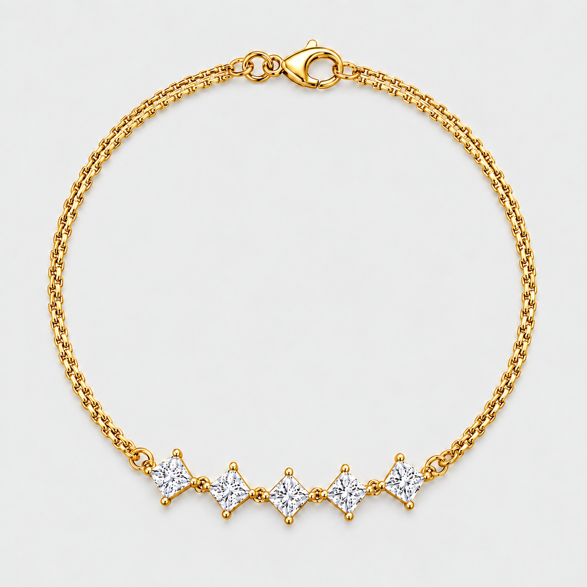 A gold chain bracelet with five diamond-shaped clear gemstones set in a row, displayed on a light gray background.