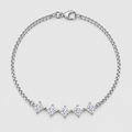A silver chain bracelet with five diamond-cut clear stones set in a row, displayed on a light gray background.
