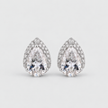 A pair of pear-shaped diamond stud earrings in a silver-toned setting, surrounded by small round diamonds, on a light gray background.