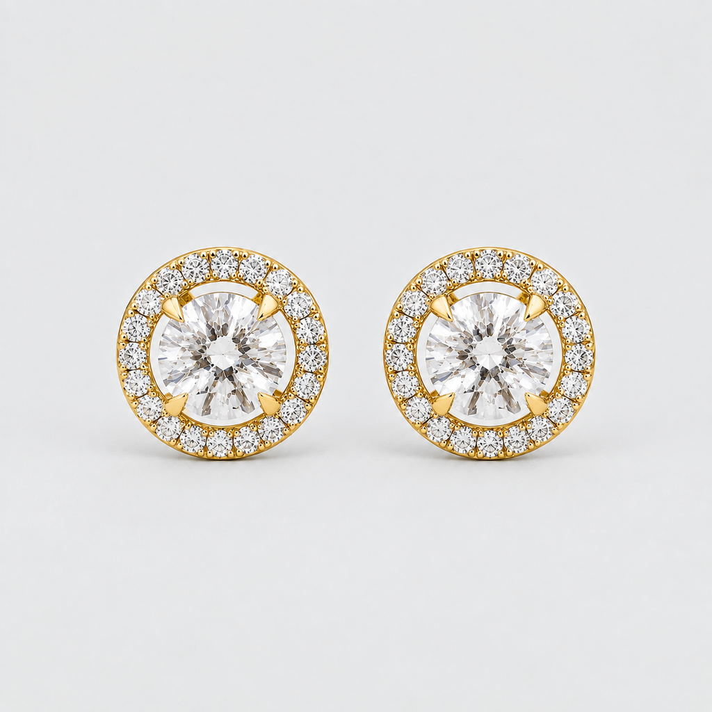 A pair of round yellow gold halo stud earrings with clear gemstones, photographed on a clean light gray background.