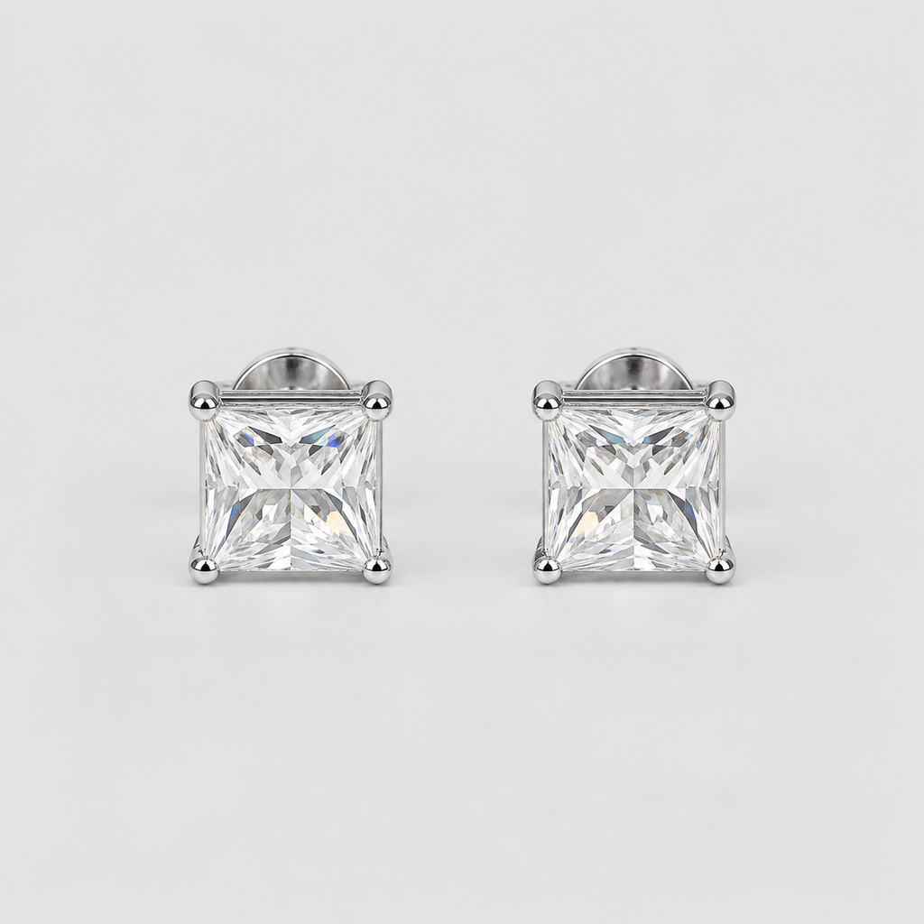 A pair of princess-cut diamond stud earrings in a silver four-prong setting, displayed on a clean light gray background.