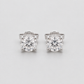 A pair of round-cut solitaire stud earrings in a silver-toned setting, displayed on a clean light gray background.