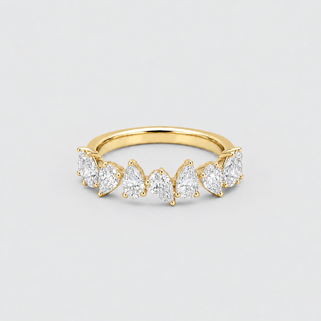 A yellow gold ring featuring a row of marquise-cut and round brilliant-cut clear gemstones in a semi-circular arrangement, set against a light gray background.