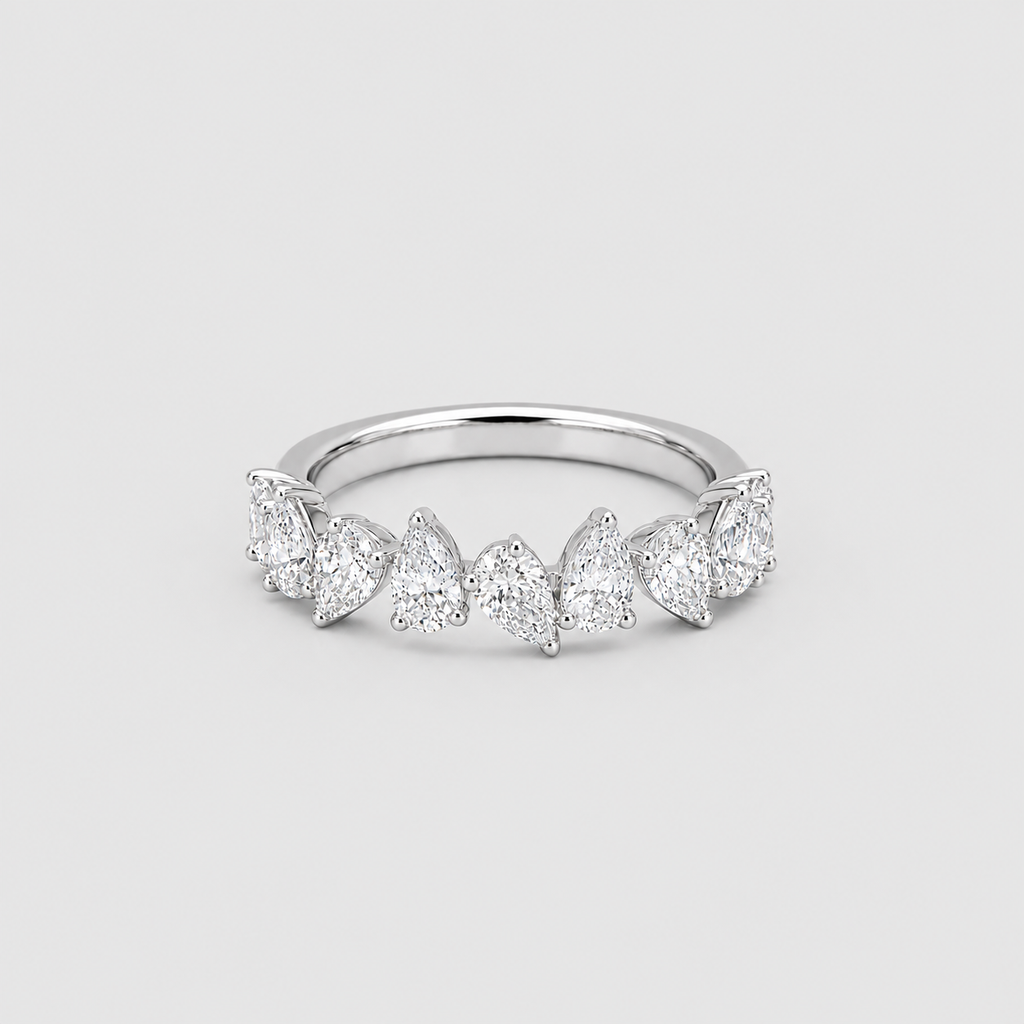 A silver band ring featuring a row of marquise-cut and round-cut clear gemstones, photographed on a light gray background.