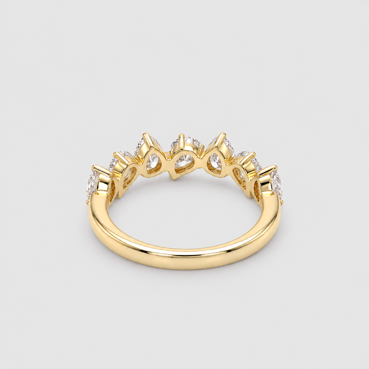 A yellow gold ring featuring a crown-like top with clear gemstones, shown on a neutral light gray background.