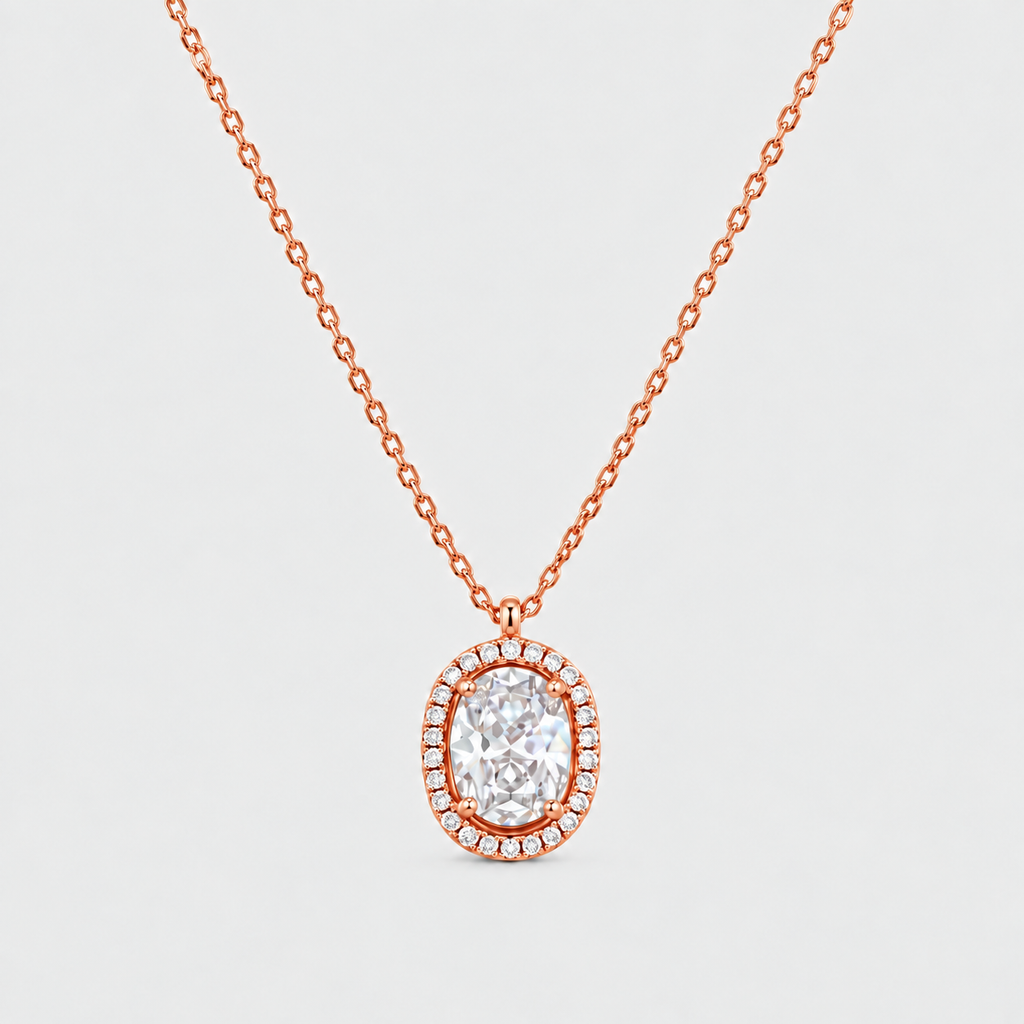 A rose gold necklace with a halo pendant featuring a central oval clear gemstone surrounded by small pavé-set stones, shown on a light gray background.