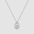 A silver-tone pendant necklace featuring a teardrop-shaped clear gemstone surrounded by a halo of smaller round stones, suspended from a delicate link chain against a light gray background.