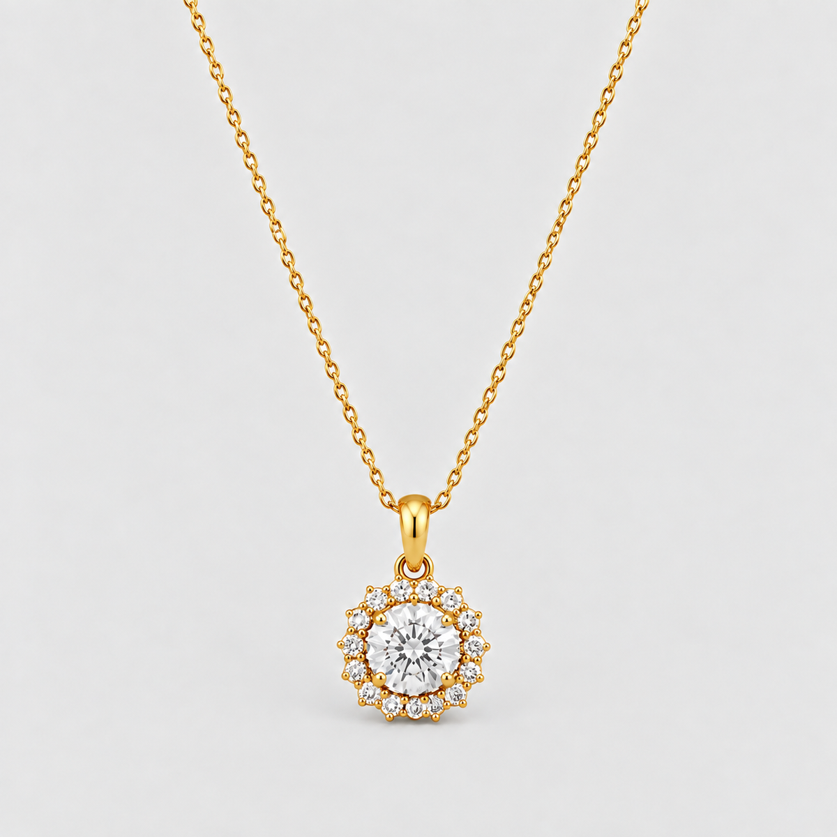 A gold necklace with a circular pendant featuring a central clear gemstone surrounded by a halo of smaller clear stones, displayed on a light gray background.