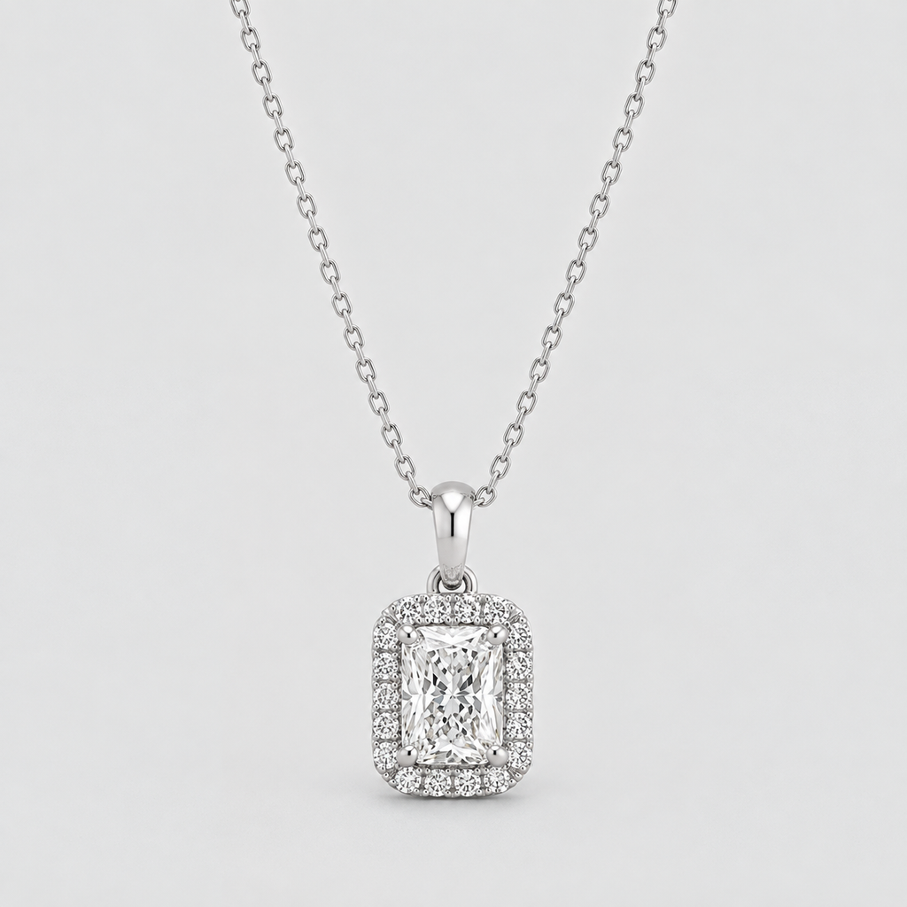 A silver-toned diamond necklace featuring an emerald-cut halo pendant, displayed against a light gray background.