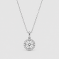 A silver pendant necklace featuring a round halo design with a central clear gemstone surrounded by a halo of smaller stones, suspended from a delicate chain against a light gray background.