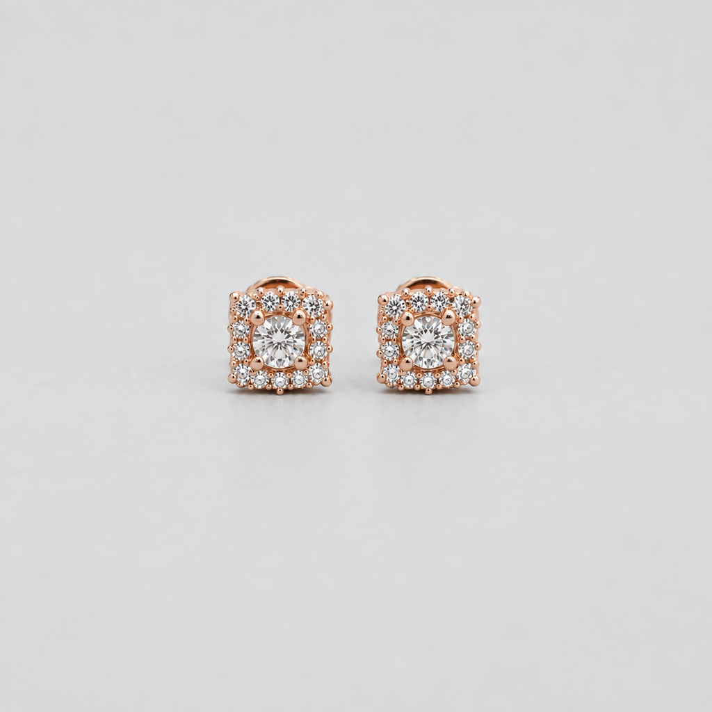 A pair of rose gold square stud earrings with a central round clear gemstone surrounded by a halo of smaller clear stones, set against a light gray background.