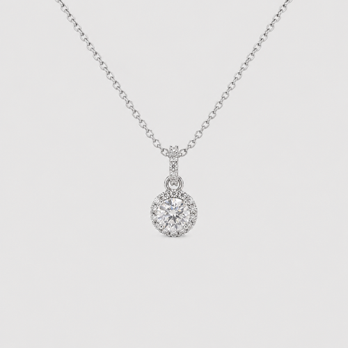 A silver-toned necklace with a round halo pendant set with clear gemstones, displayed against a light gray background.