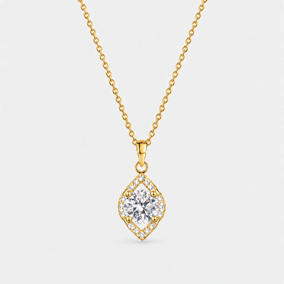 A gold diamond-shaped pendant necklace featuring a central clear gemstone surrounded by a halo of small diamonds, suspended from a delicate gold chain against a light gray background.