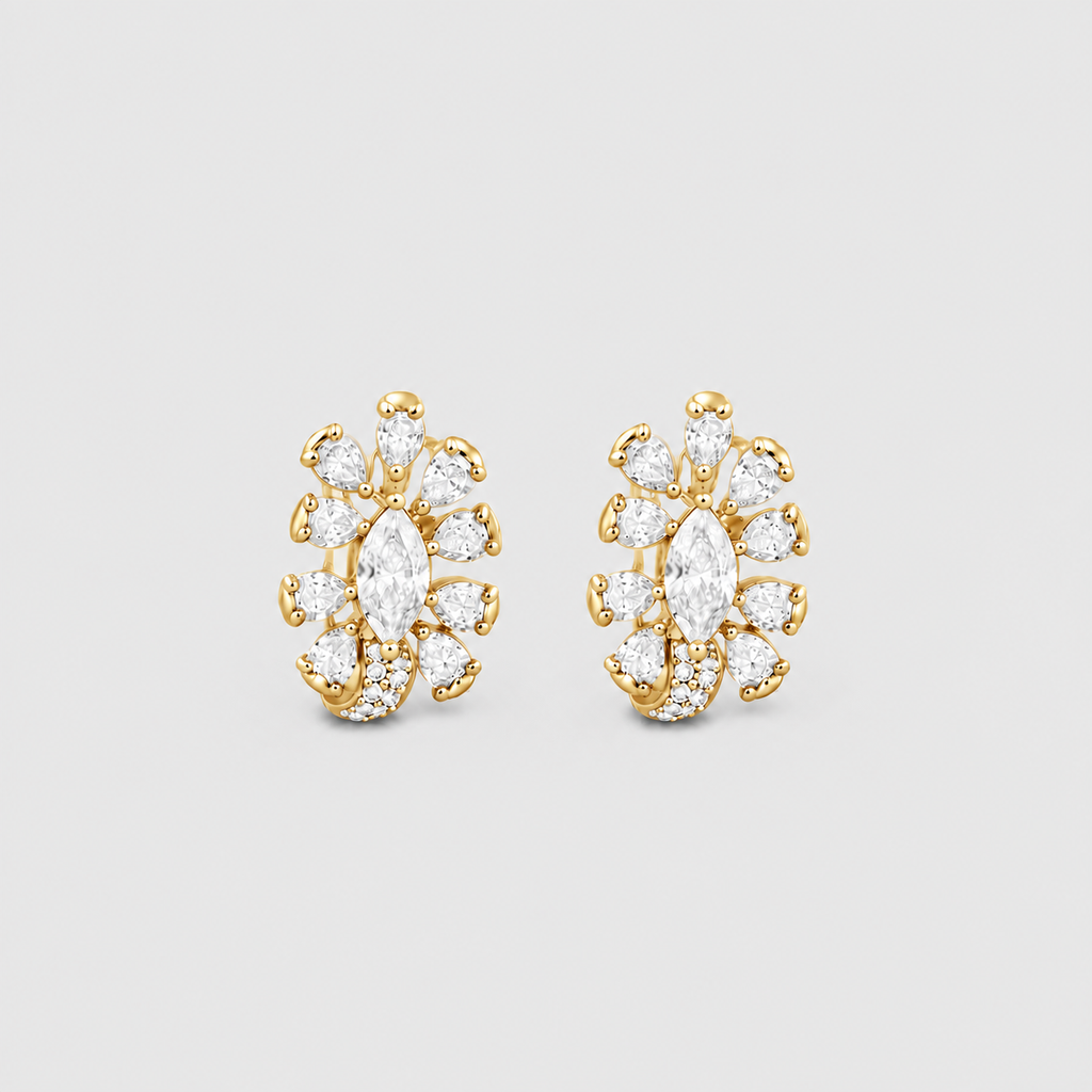 A pair of gold and diamond stud earrings with marquise-cut center stones and surrounding round and oval diamonds, displayed on a light gray background.
