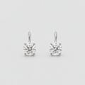 A pair of solitaire drop earrings with round brilliant-cut clear gemstones in a silver-toned four-prong setting, suspended from simple silver-toned hooks against a light gray background.