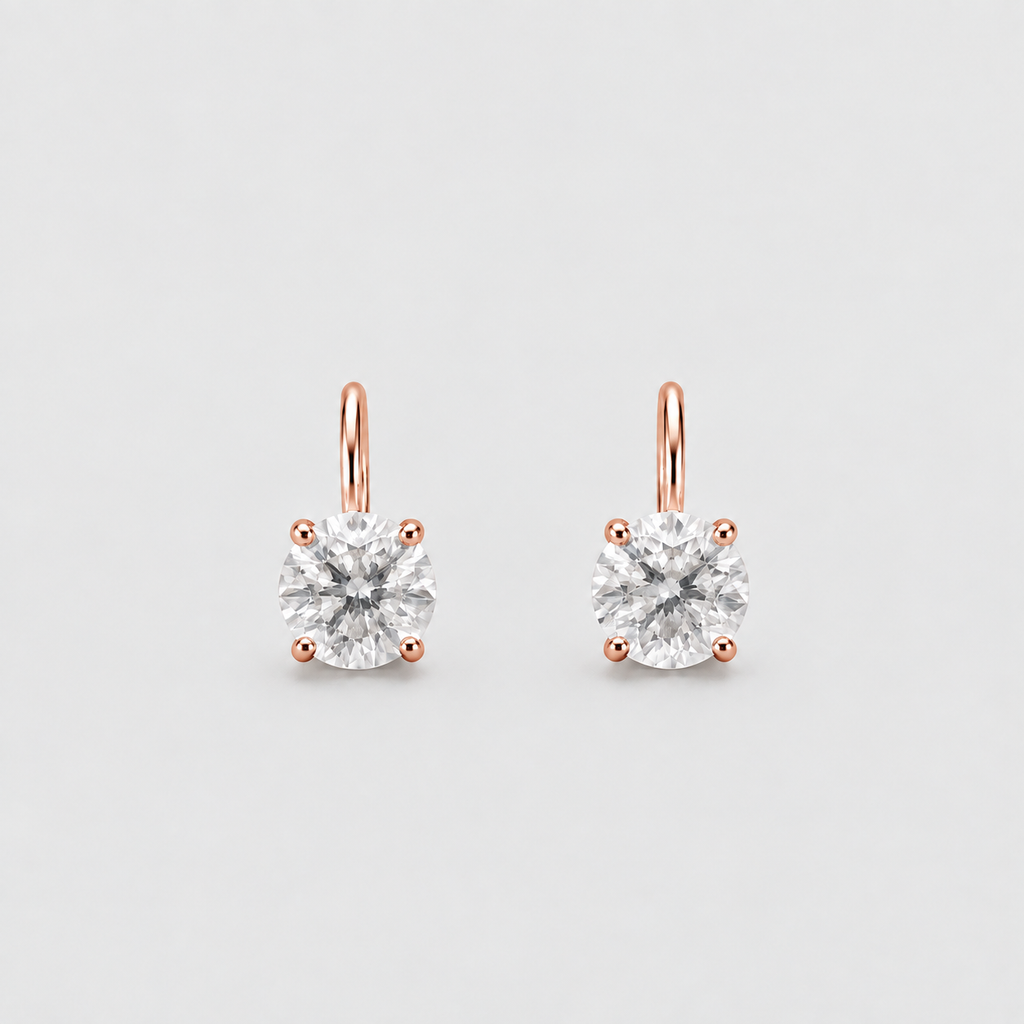A pair of rose gold stud earrings with round-cut clear gemstones in four-prong settings, shown on a light gray background.
