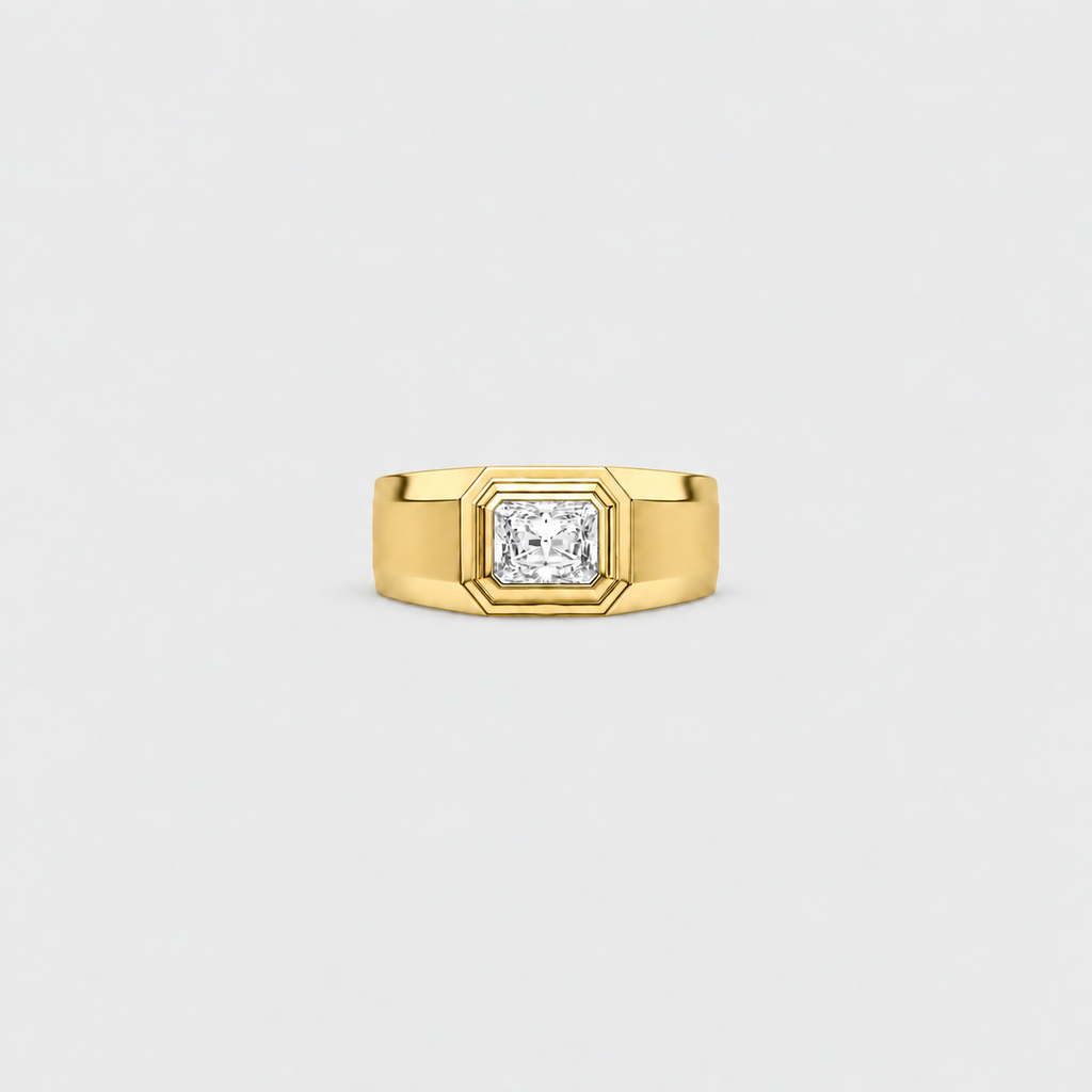 A yellow gold ring with a square bezel setting holding a princess-cut diamond, centered on a light gray background.