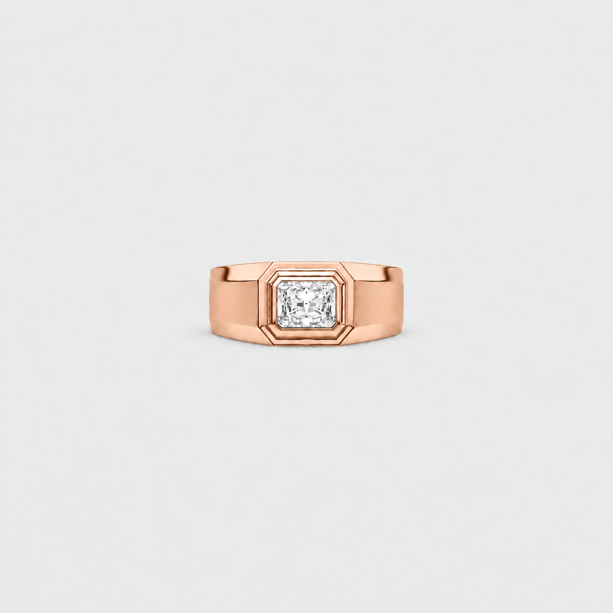 A rose gold ring with a square bezel setting holding a round brilliant-cut diamond, centered on a light gray background.