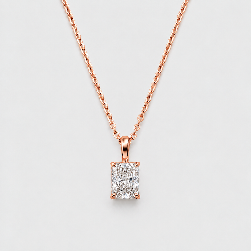 A rose gold necklace with a rectangular emerald-cut diamond pendant, displayed against a clean, light gray background.