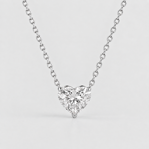 A heart-shaped diamond pendant necklace on a delicate silver chain, photographed against a clean, light gray background.