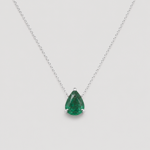 A pear-cut green gemstone pendant necklace in a silver prong setting on a delicate silver chain, shown against a light gray background.