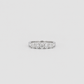 A silver diamond band ring featuring five round-cut diamonds set in a row, photographed against a solid light gray background.