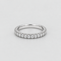 A silver-tone diamond eternity ring with a continuous row of round-cut diamonds set on a plain light gray background.