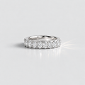A silver diamond eternity ring with a row of round-cut diamonds set in a polished silver band, photographed on a clean light gray background.