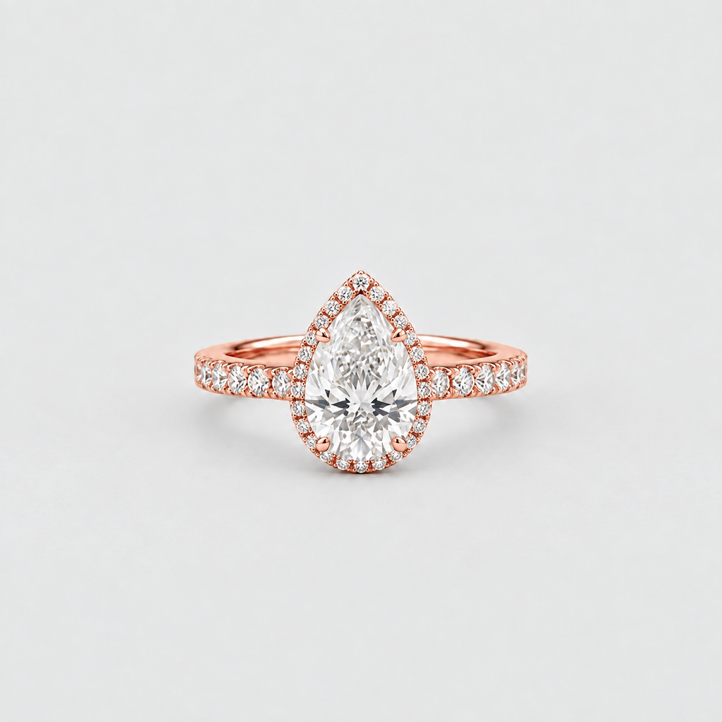 A pear-cut diamond halo ring in rose gold, featuring a large central pear-shaped diamond surrounded by a halo of smaller diamonds, with a matching diamond-accented band, set against a light gray background.