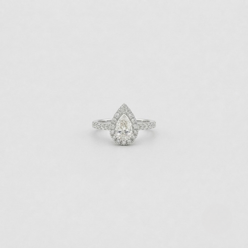 A pear-cut halo ring with a pavé band, set in a silver-toned metal on a light gray background.