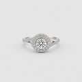 A silver-toned halo ring featuring a round-cut center stone surrounded by a double halo of small pavé-set stones, with a split shank band, shown on a light gray background.