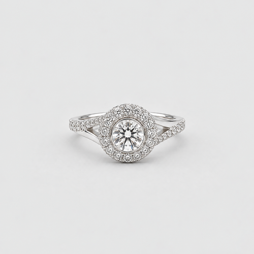 A silver-toned halo ring featuring a round-cut center stone surrounded by a double halo of small pavé-set stones, with a split shank band, shown on a light gray background.